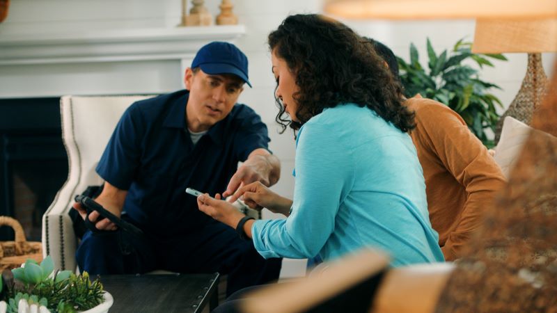 Technician Talking To Family People Talking In A Home